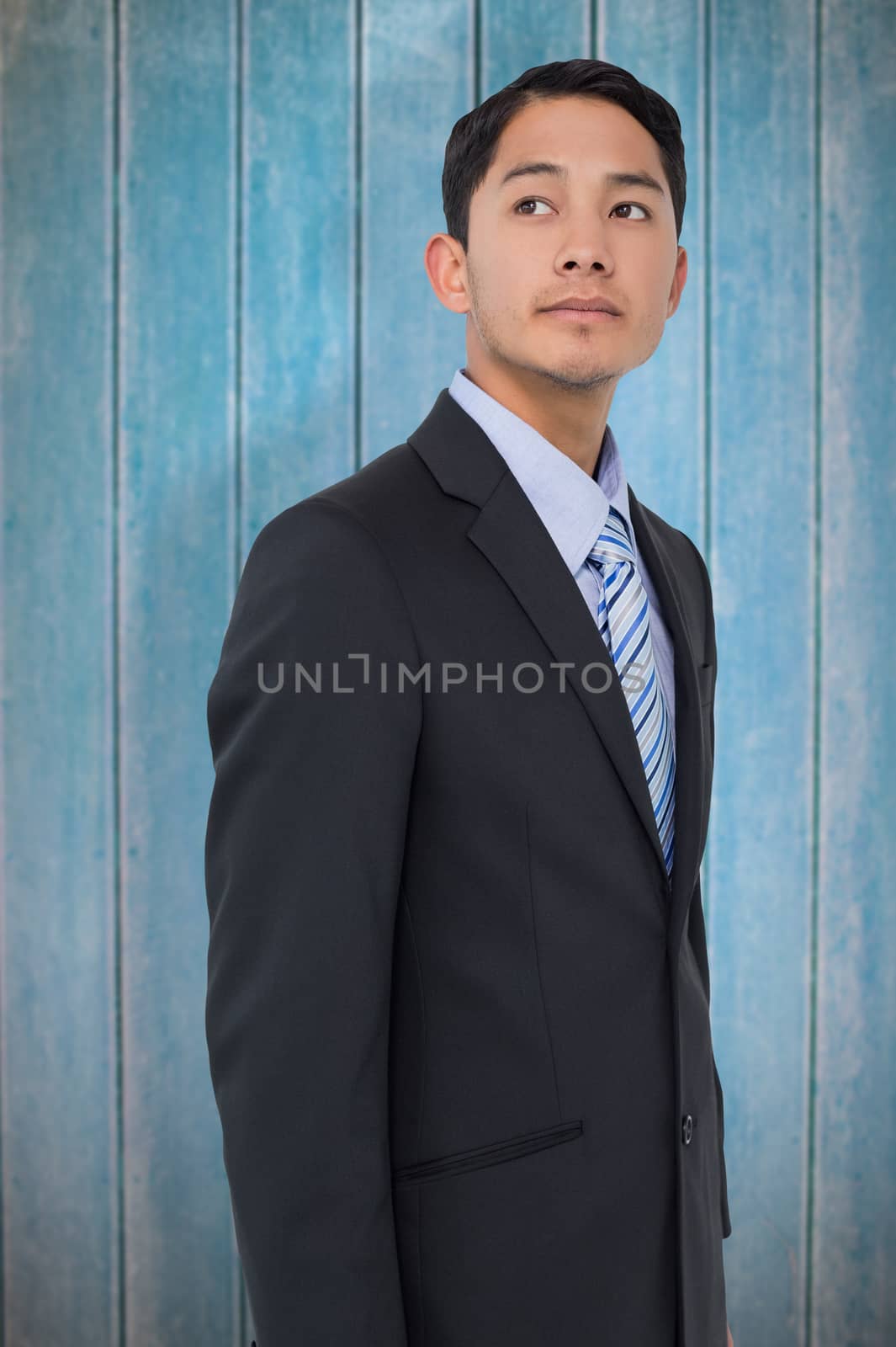 Serious asian businessman  against wooden planks