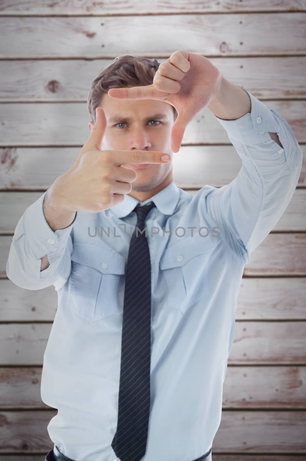 Businessman making frame with hands against wooden planks