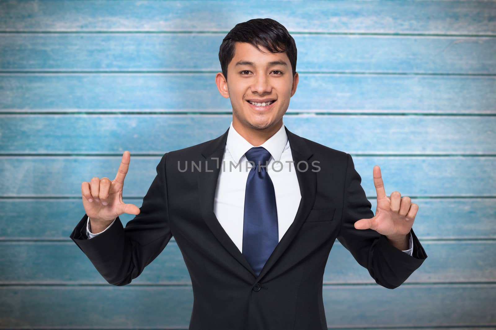 Smiling businessman holding against wooden planks