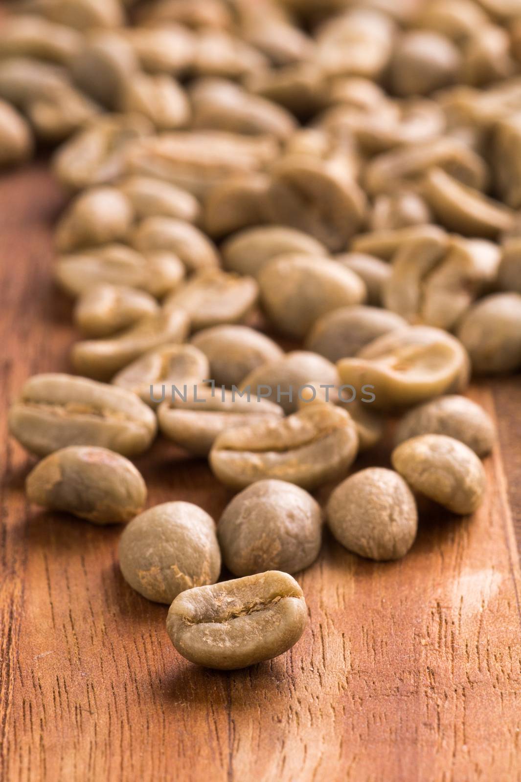 Green Coffee Beans placed on a wood cutting board by blegate