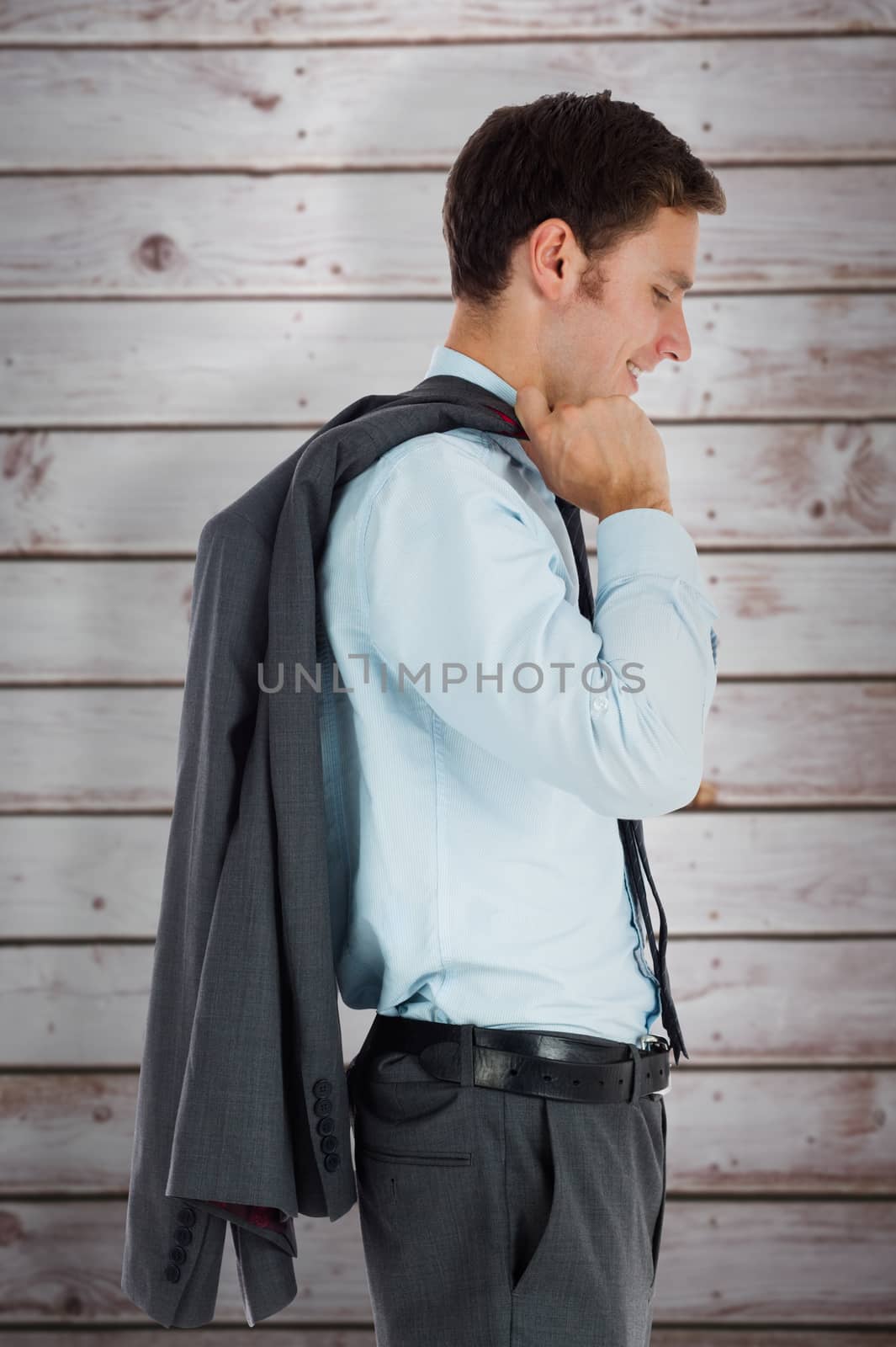 Composite image of smiling businessman holding his jacket by Wavebreakmedia