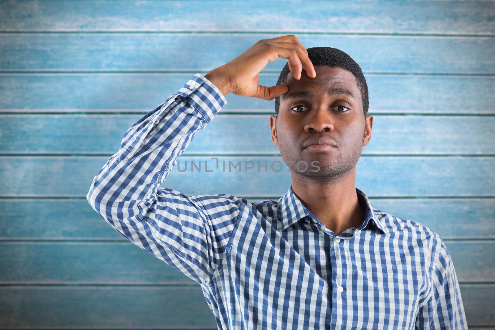 Young businessman thinking against wooden planks