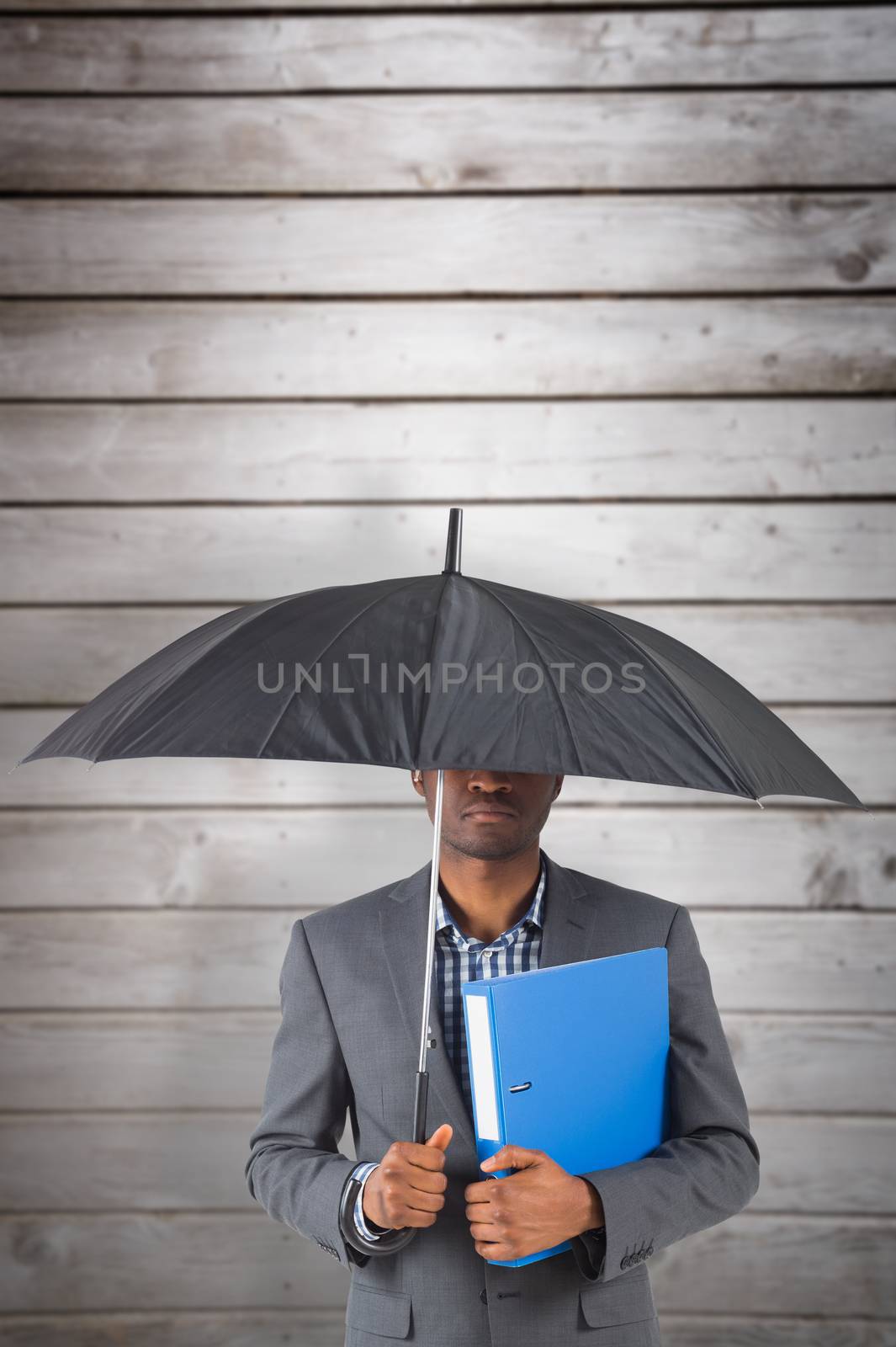 Composite image of businessman standing under umbrella by Wavebreakmedia