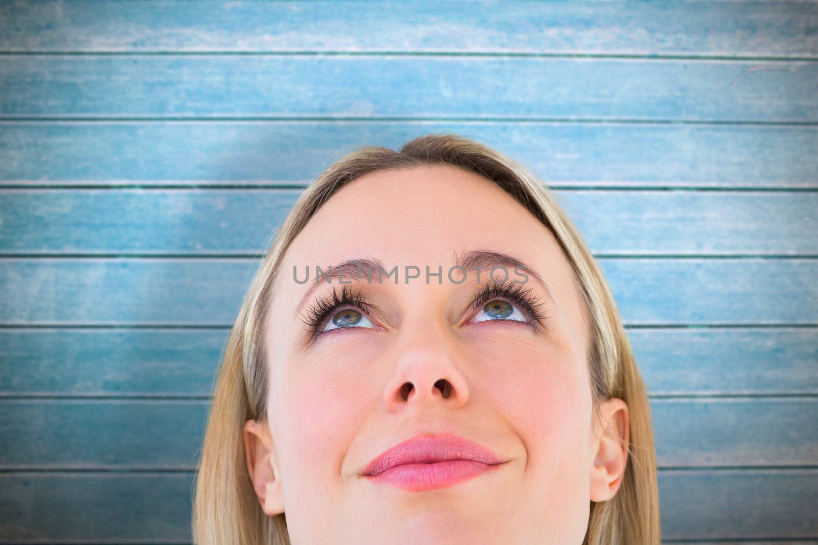 Composite image of close up of smiling blonde woman looking up by Wavebreakmedia