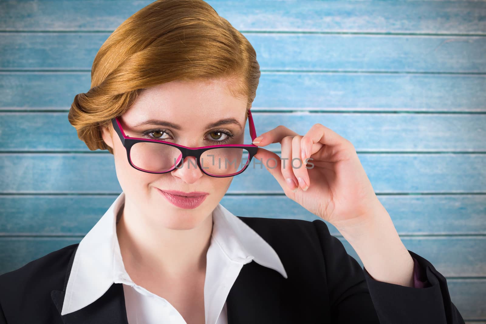 Redhead businesswoman touching her glasses against wooden planks