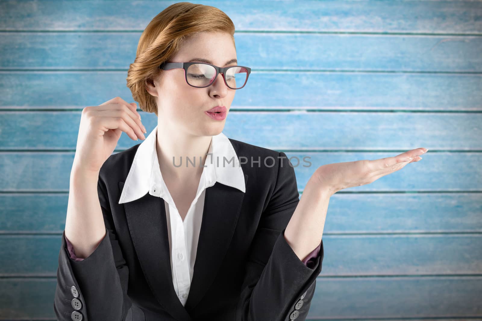 Businesswoman holding hand out in presentation against wooden planks