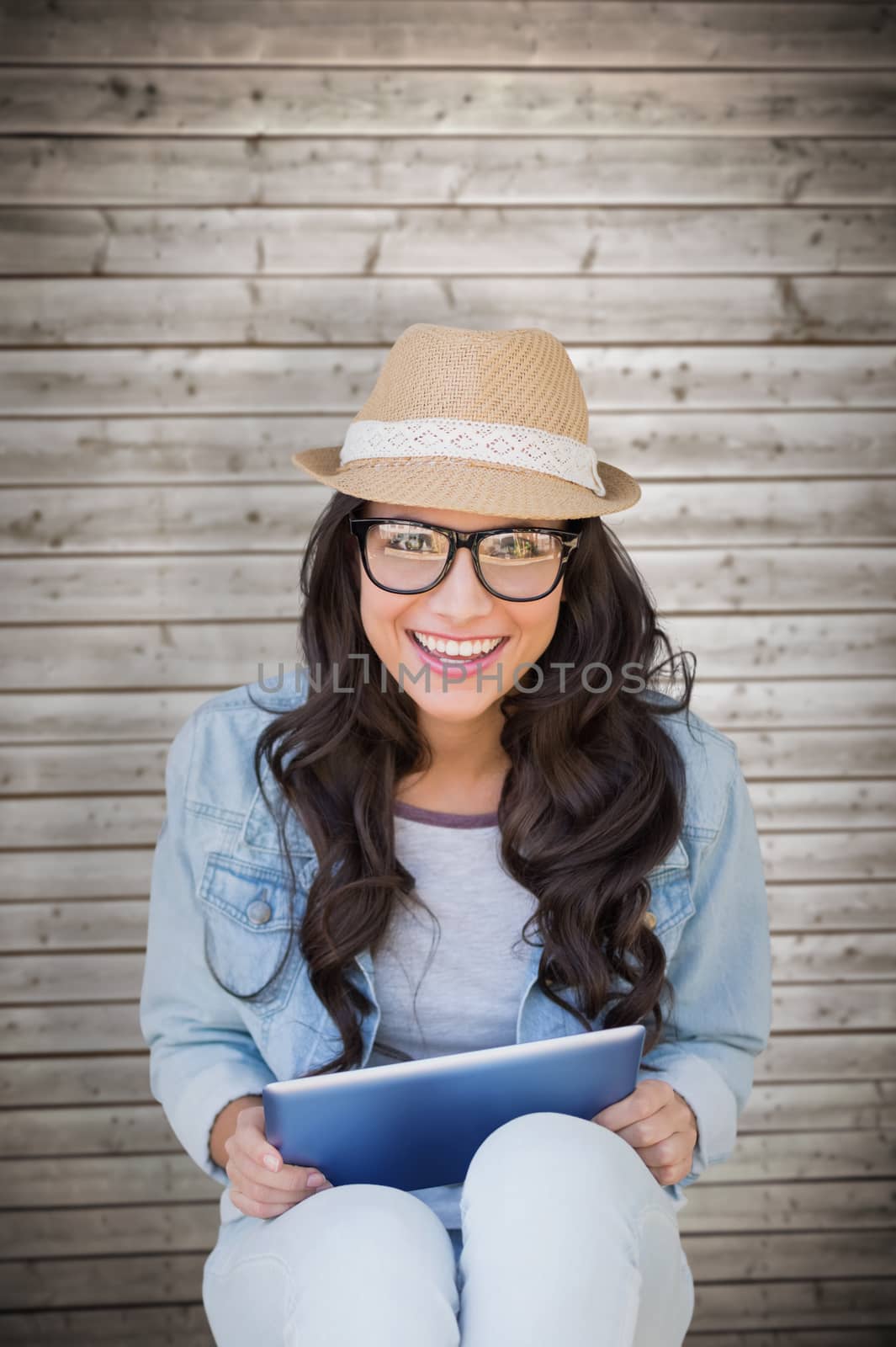Brunette with tablet pc against wooden planks background