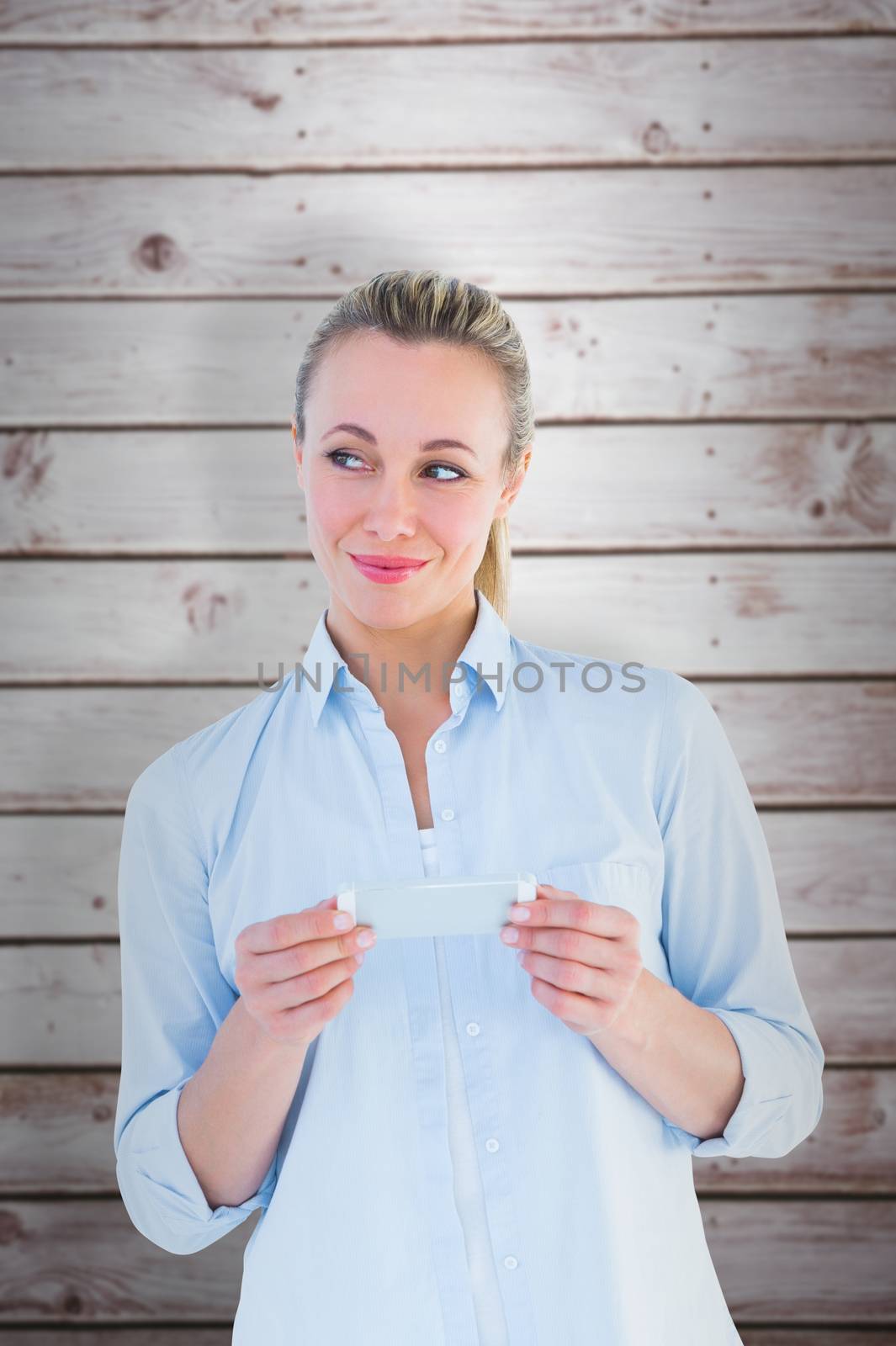 Composite image of beautiful blonde smiling and holding by Wavebreakmedia