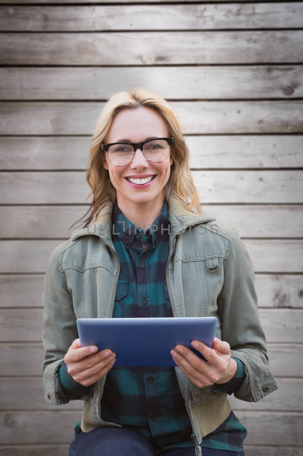 Blonde using tablet pc against wooden planks