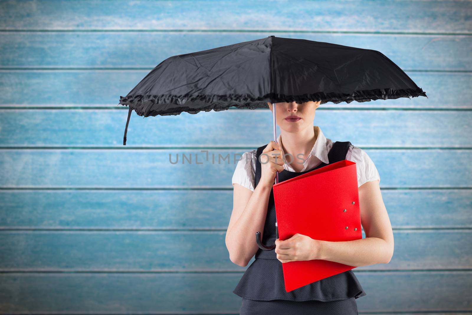 Composite image of pretty redhead businesswoman holding umbrella by Wavebreakmedia