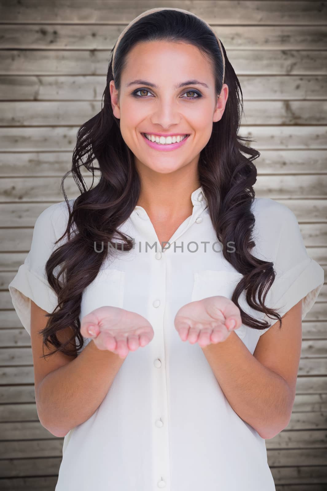 Pretty brunette holding out hands against wooden planks background