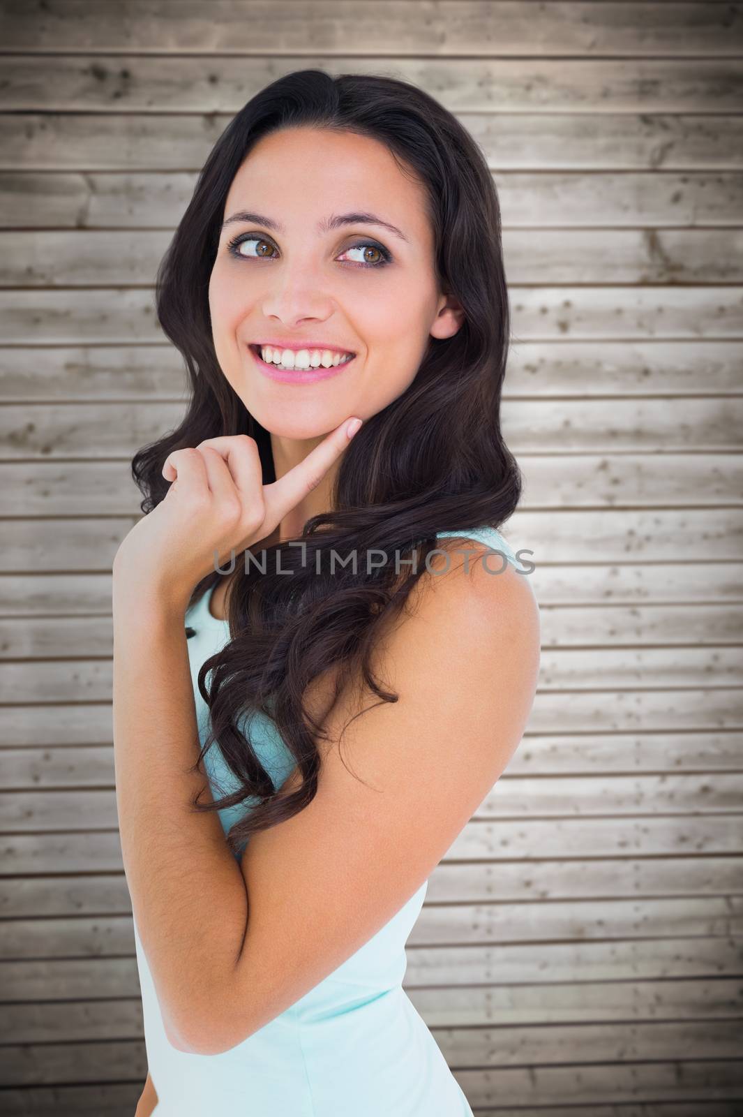 Pretty brunette getting an idea against wooden planks background