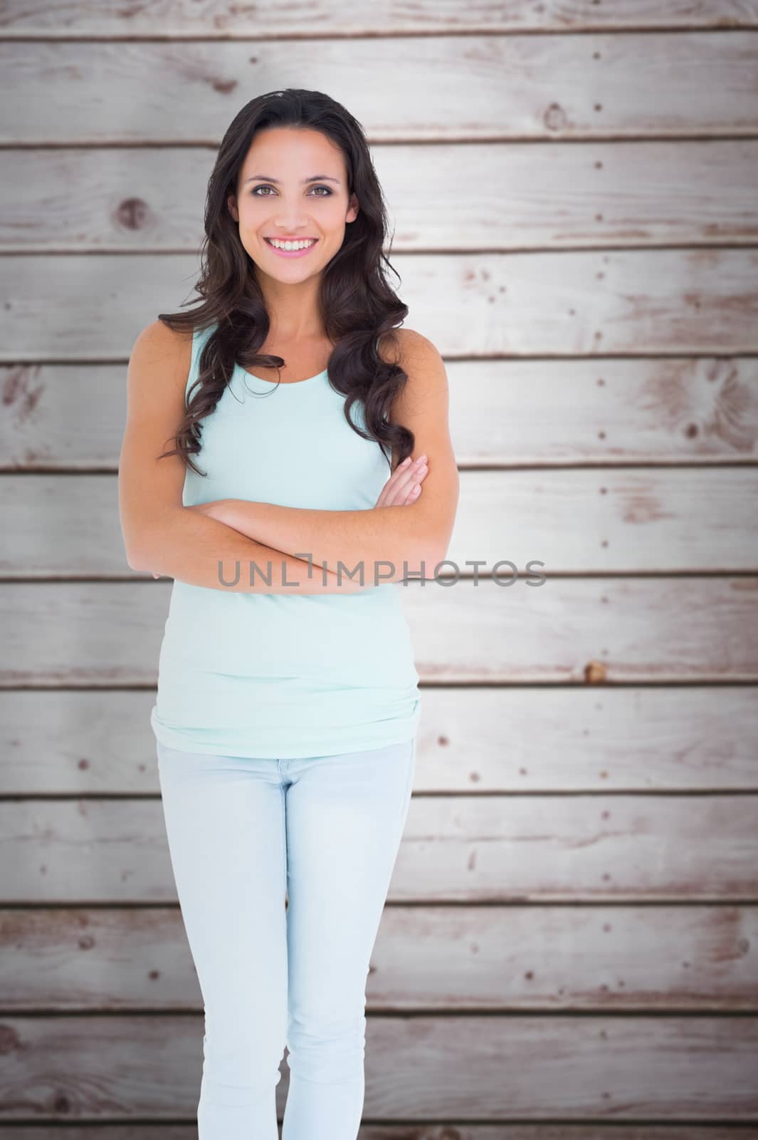 Pretty brunette smiling at camera against wooden planks