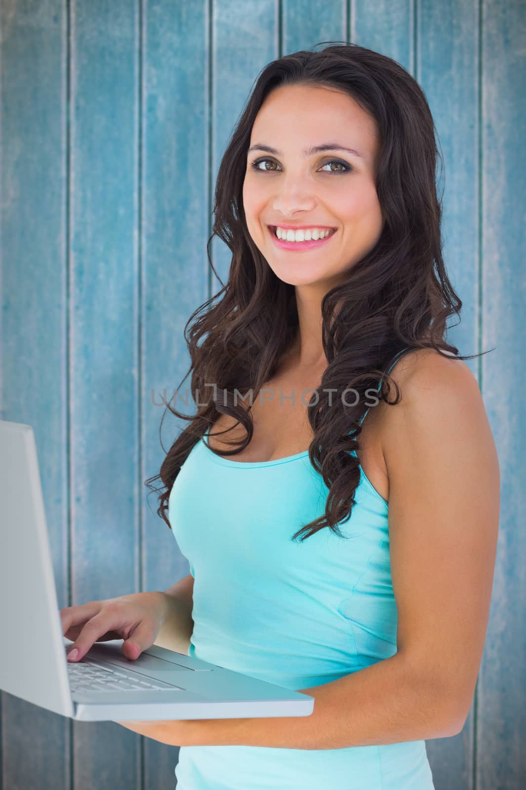 Composite image of casual brunette using her laptop by Wavebreakmedia