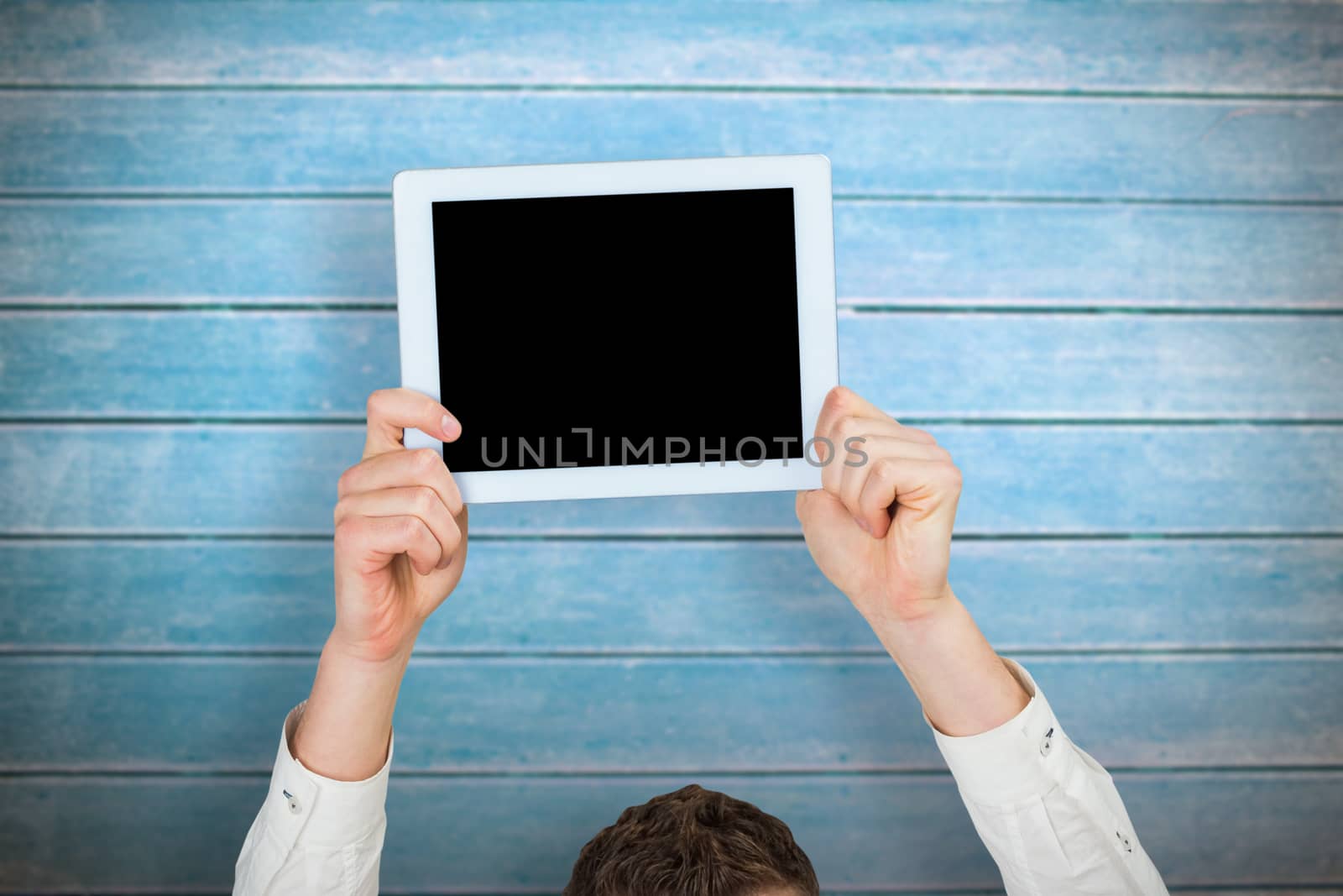 Composite image of businessman showing tablet above head by Wavebreakmedia