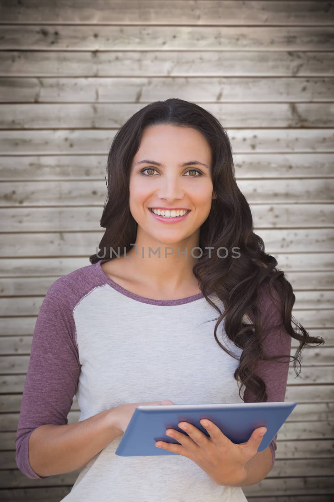 Composite image of brunette using tablet pc by Wavebreakmedia