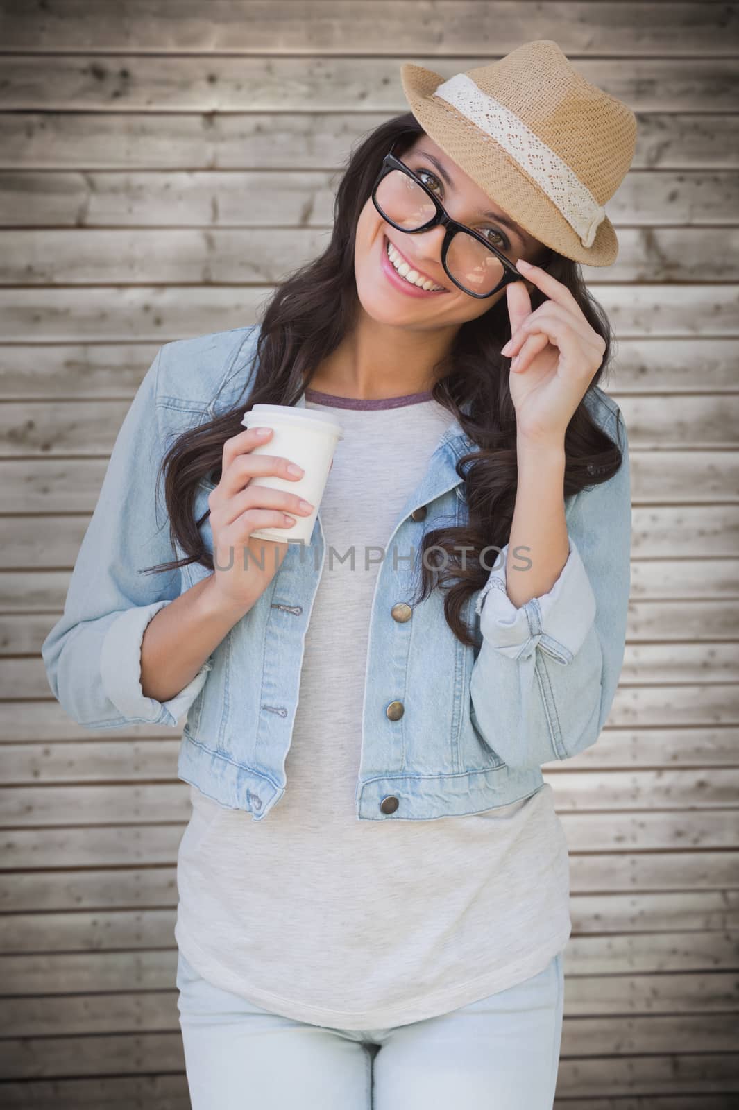 Brunette with disposable cup against wooden planks background