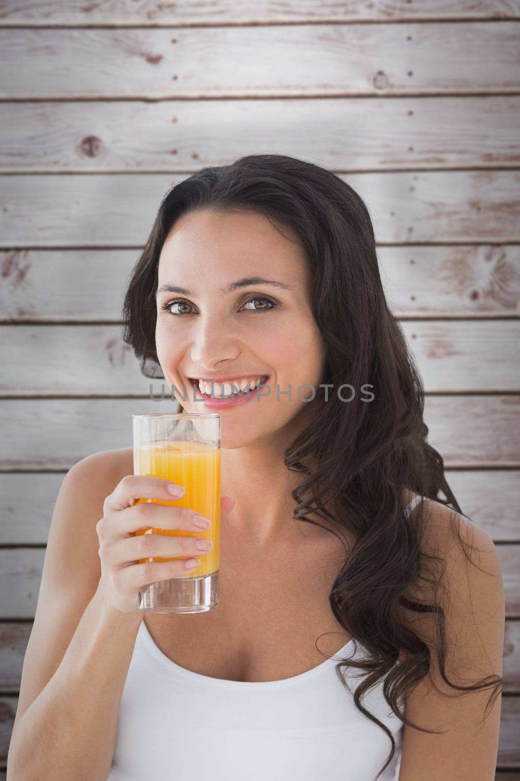 Brunette with orange juice against wooden planks