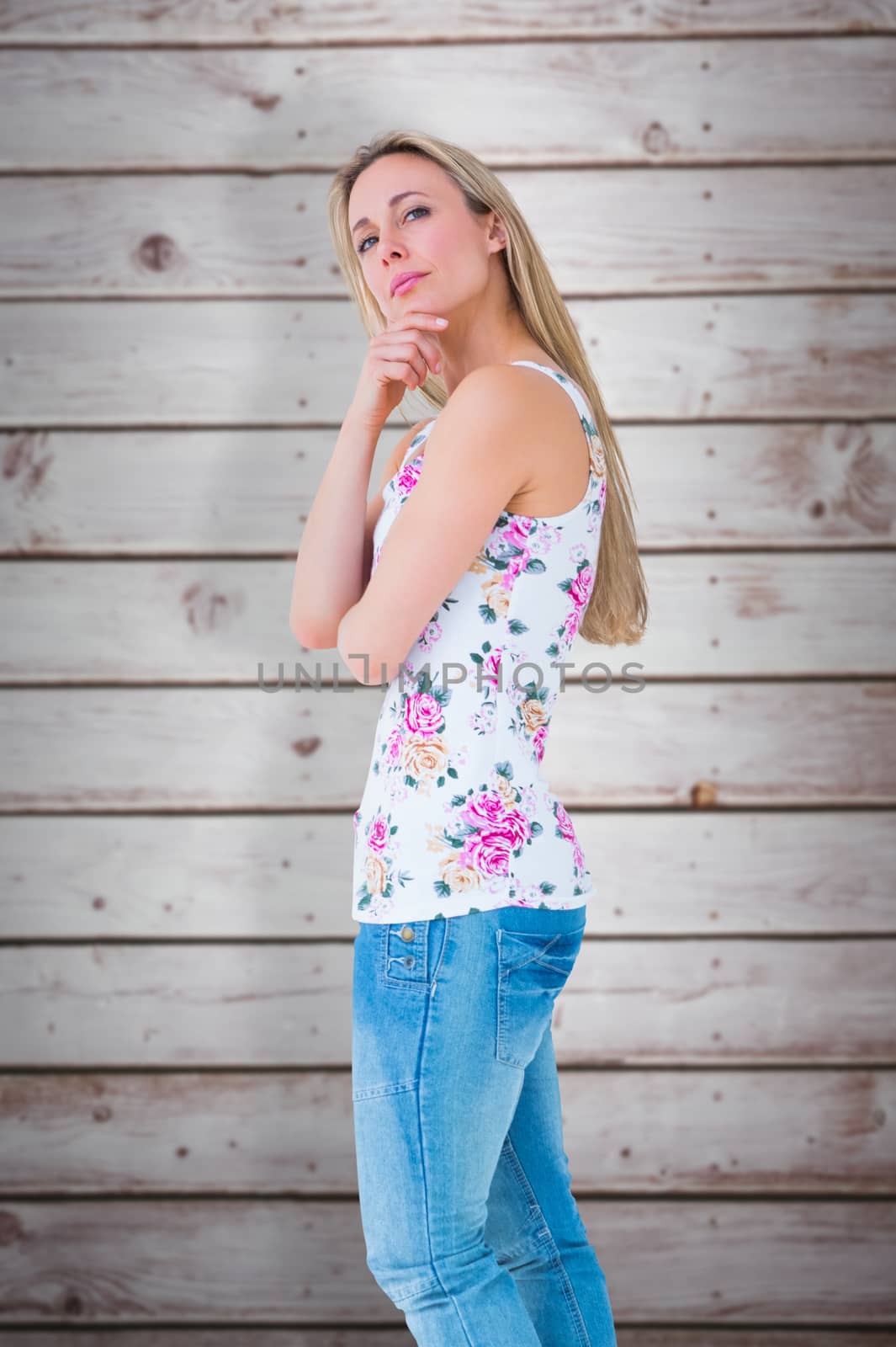 Composite image of pretty blonde thinking with hand on chin by Wavebreakmedia