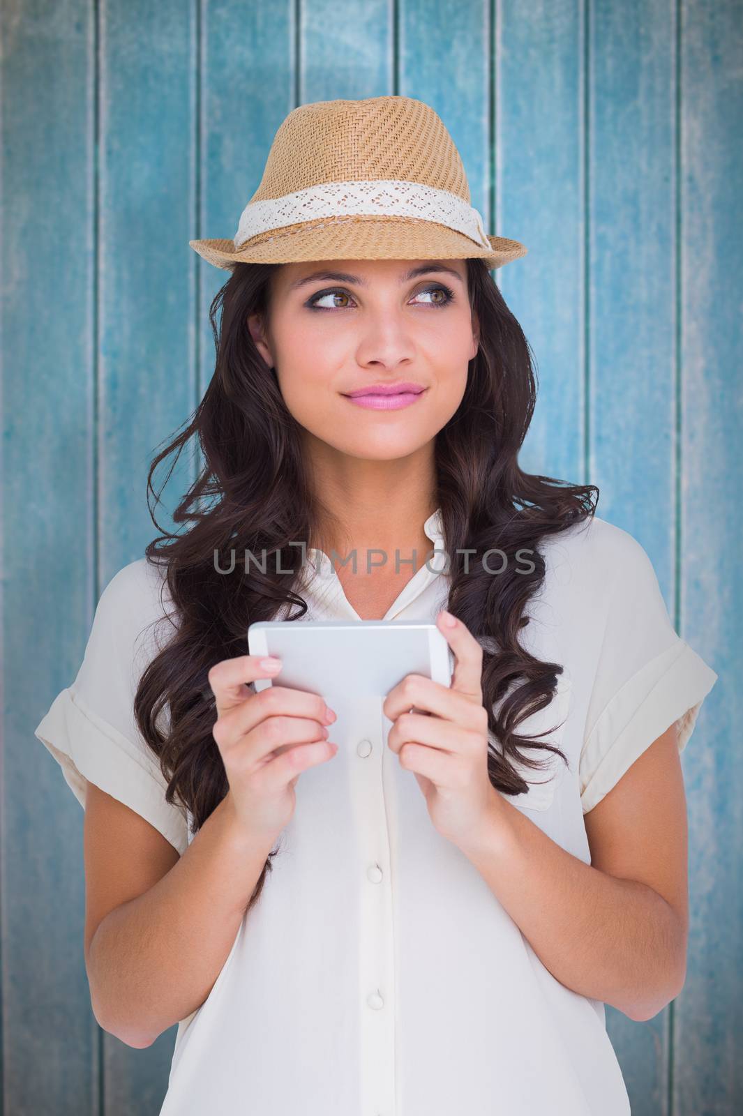 Pretty brunette holding her phone against wooden planks