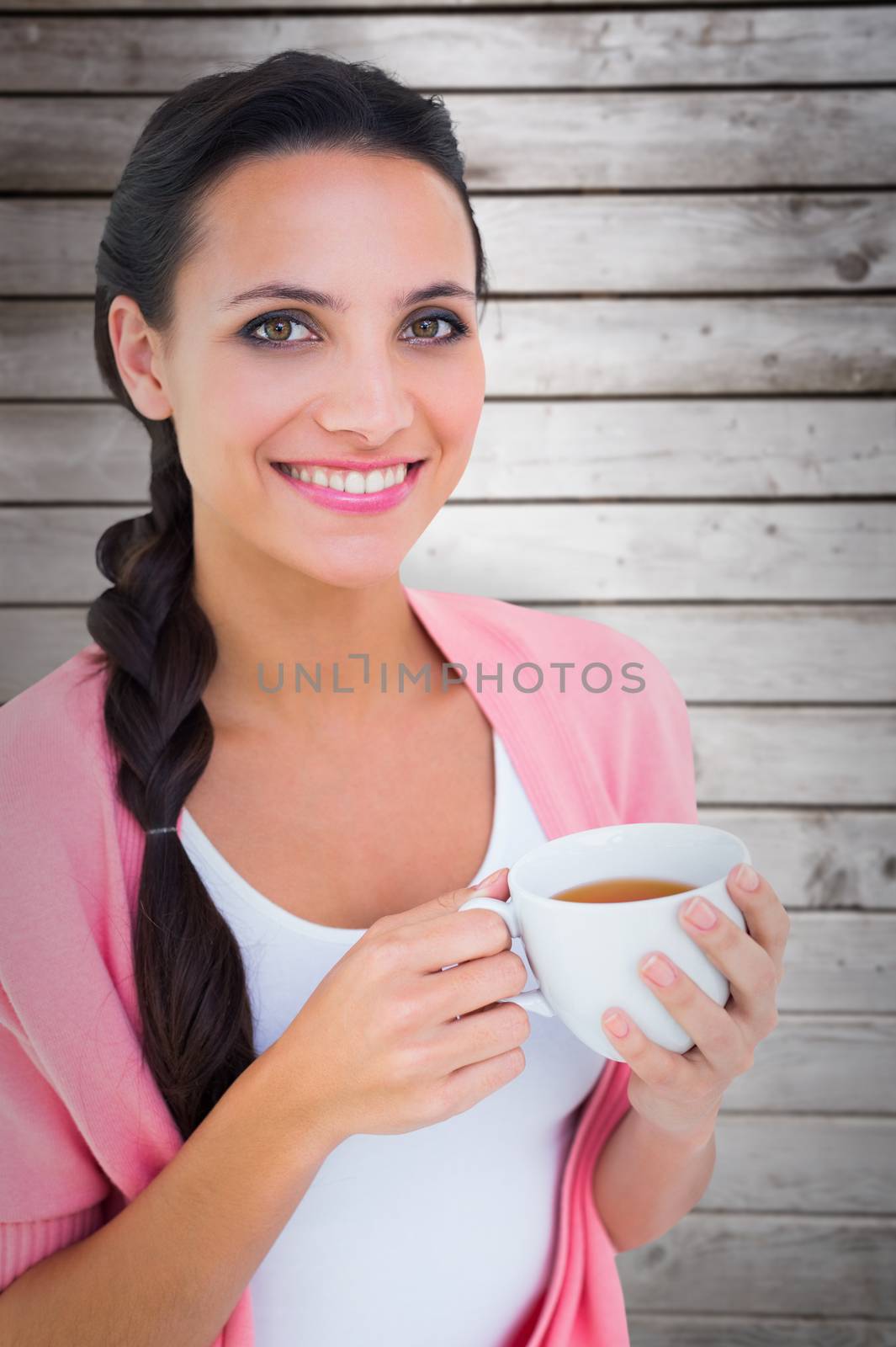 Composite image of pretty brunette holding a mug by Wavebreakmedia