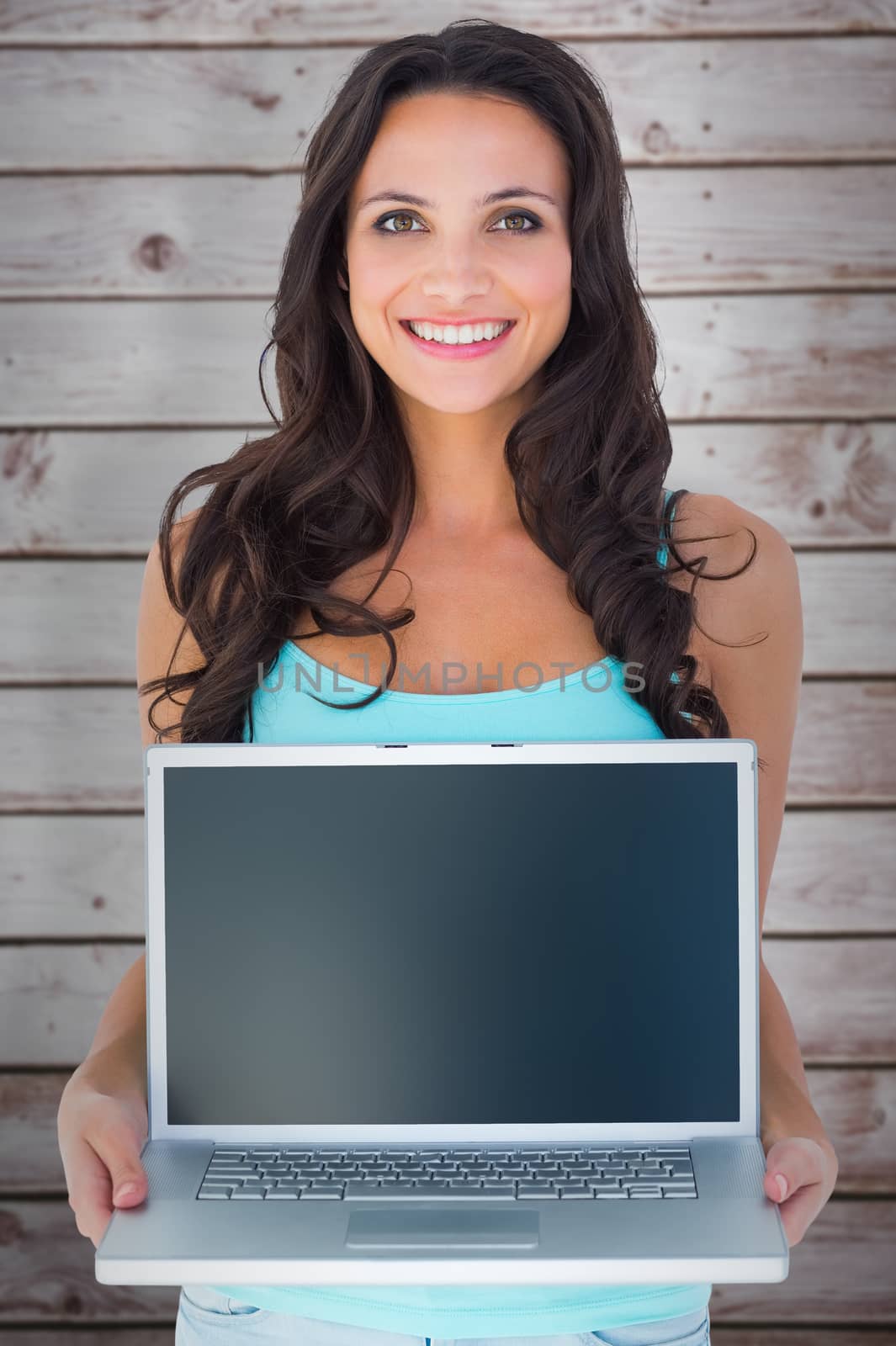 Casual brunette using her laptop against wooden planks