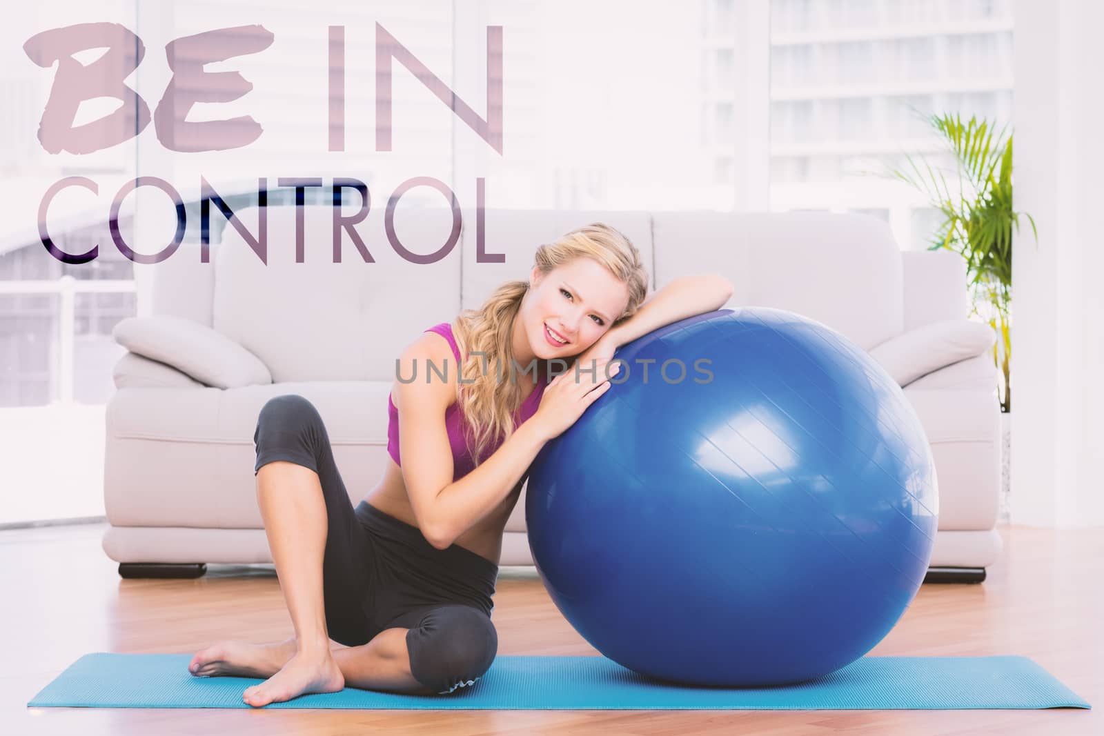 Composite image of toned blonde sitting beside exercise ball smiling at camera by Wavebreakmedia