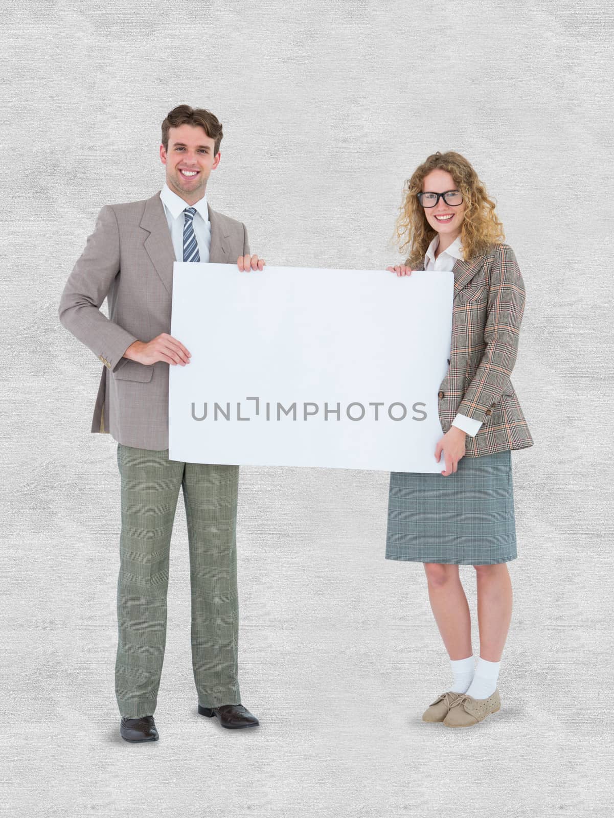 Hipster couple holding poster smiling at camera against white background