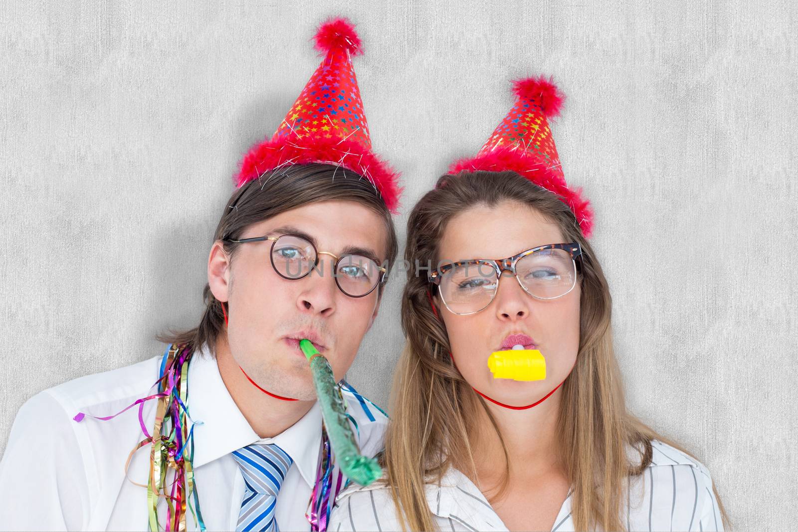 Composite image of geeky hipster wearing a party hat with blowing party horn by Wavebreakmedia