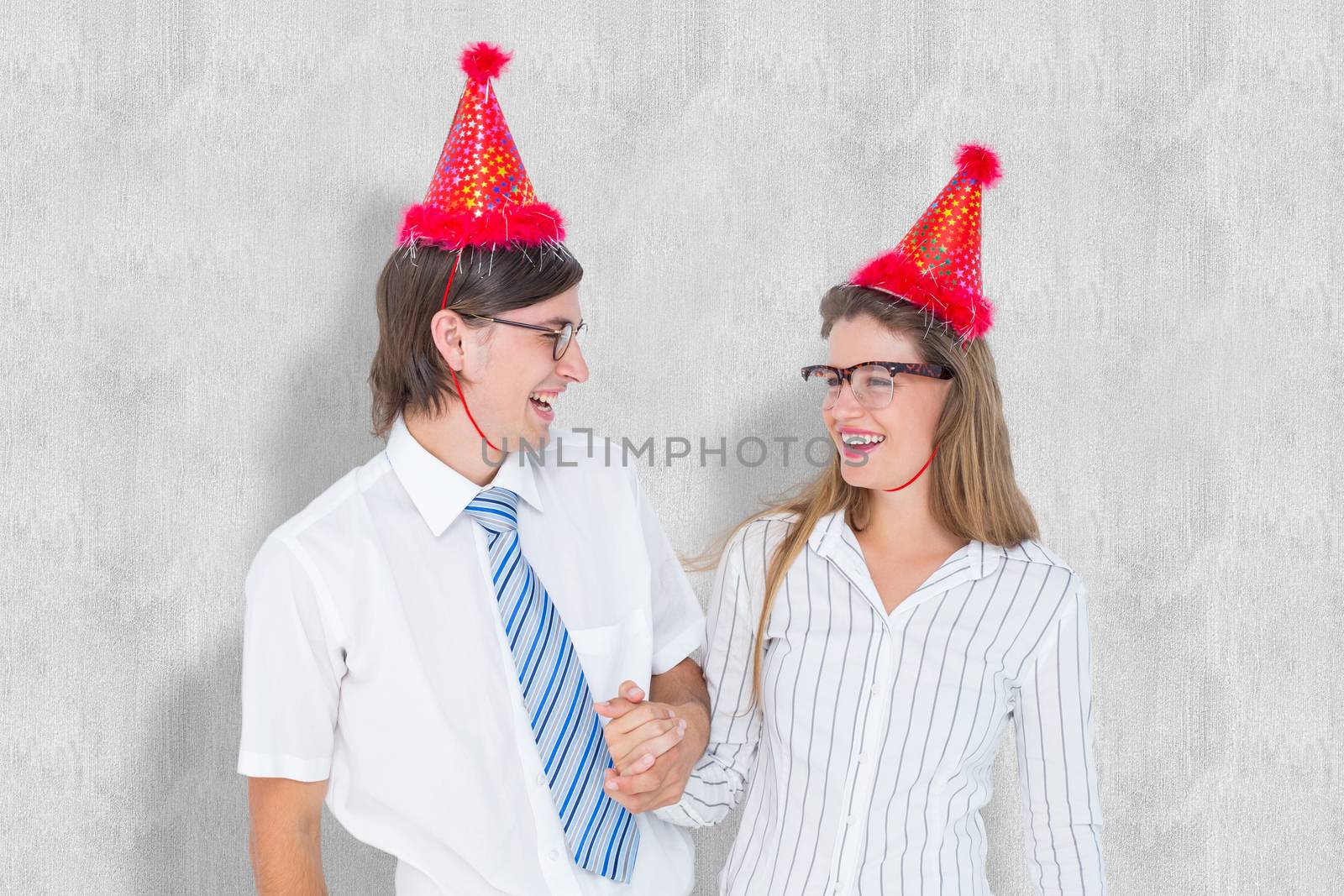 Happy geeky hipster couple with party hat  against white background