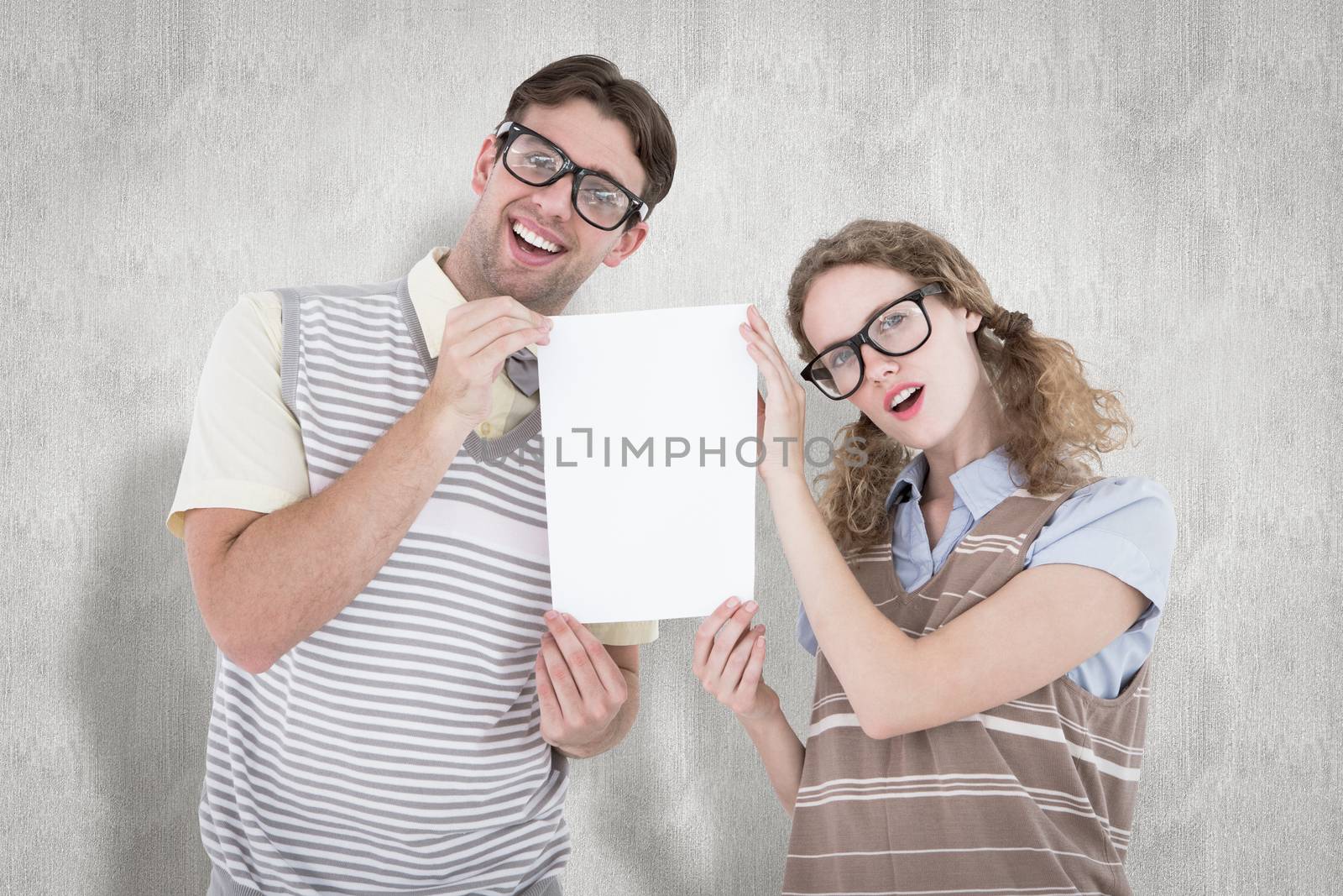 Geeky hipster couple holding poster against white background