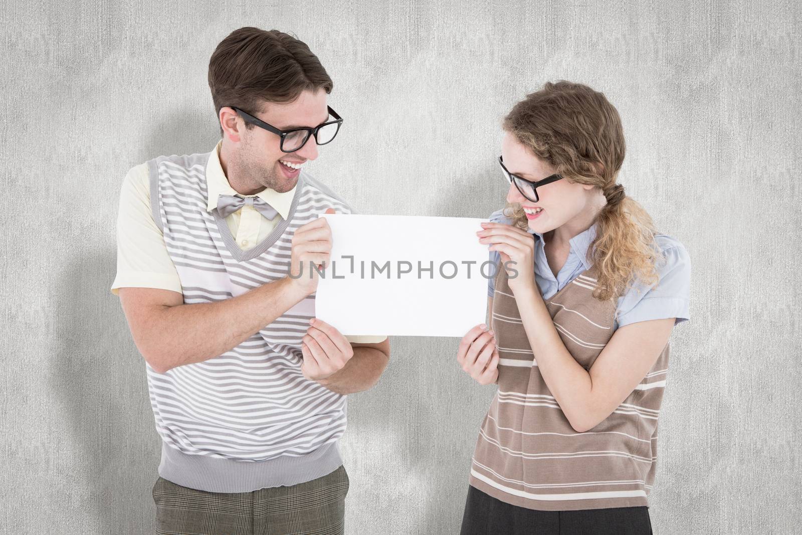 Geeky hipster couple holding poster against white background