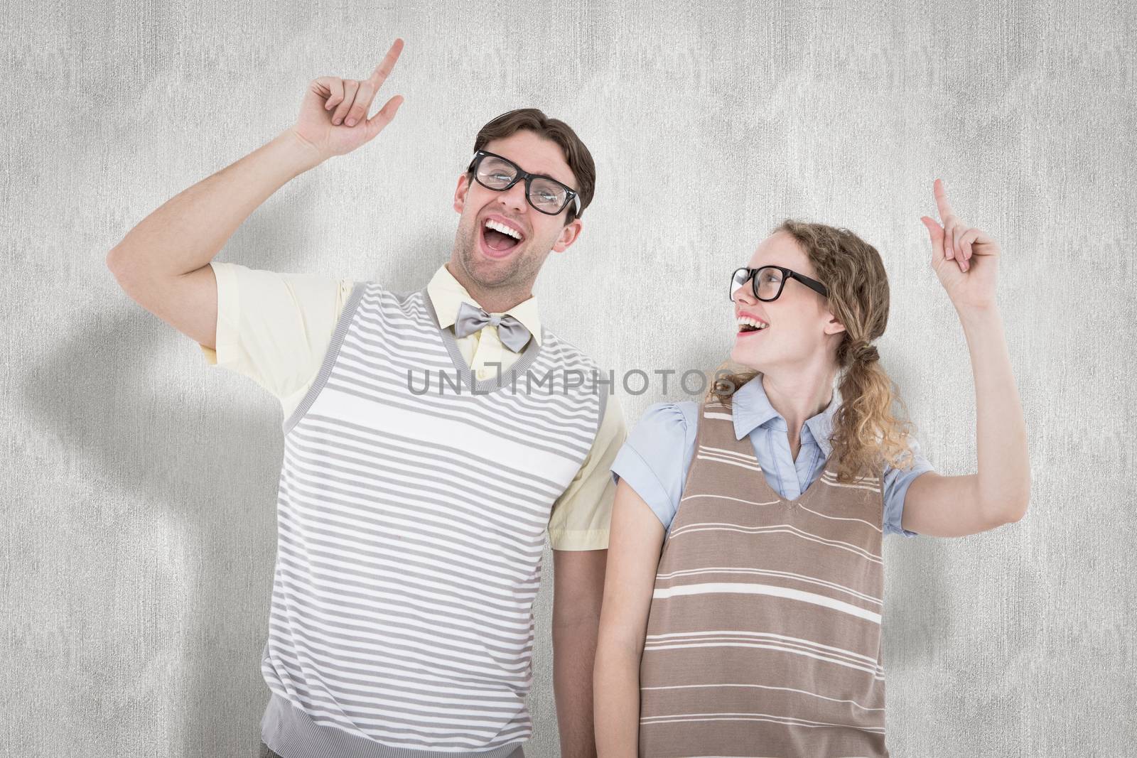 Happy geeky hipster couple pointing up against white background