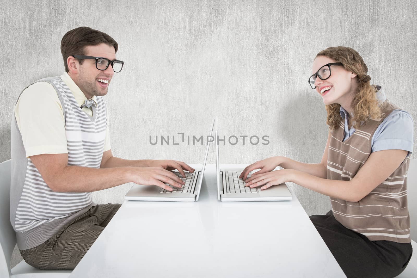 Geeky hipster couple using laptop against white background