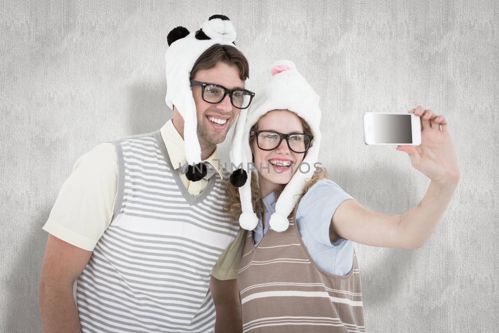 Composite image of geeky hipster couple taking selfie with smartphone by Wavebreakmedia