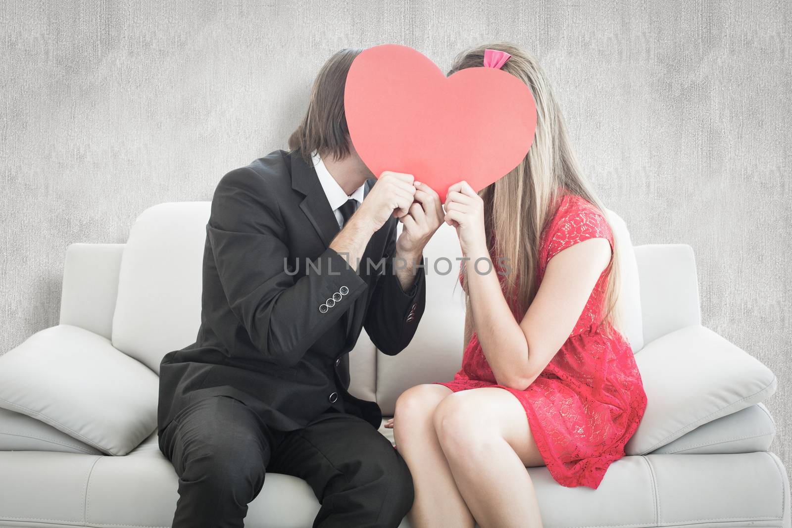 Composite image of cute geeky couple kissing and holding heart over faces by Wavebreakmedia