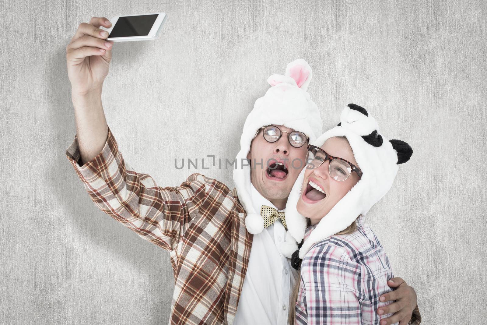 Composite image of geeky hipster couple taking selfie with smart phone  by Wavebreakmedia