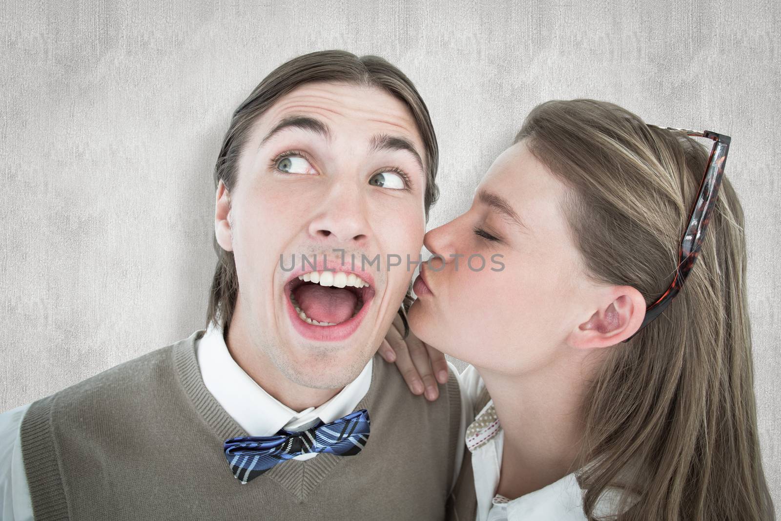 Pretty geeky hipster giving boyfriend kiss on the cheek against white background