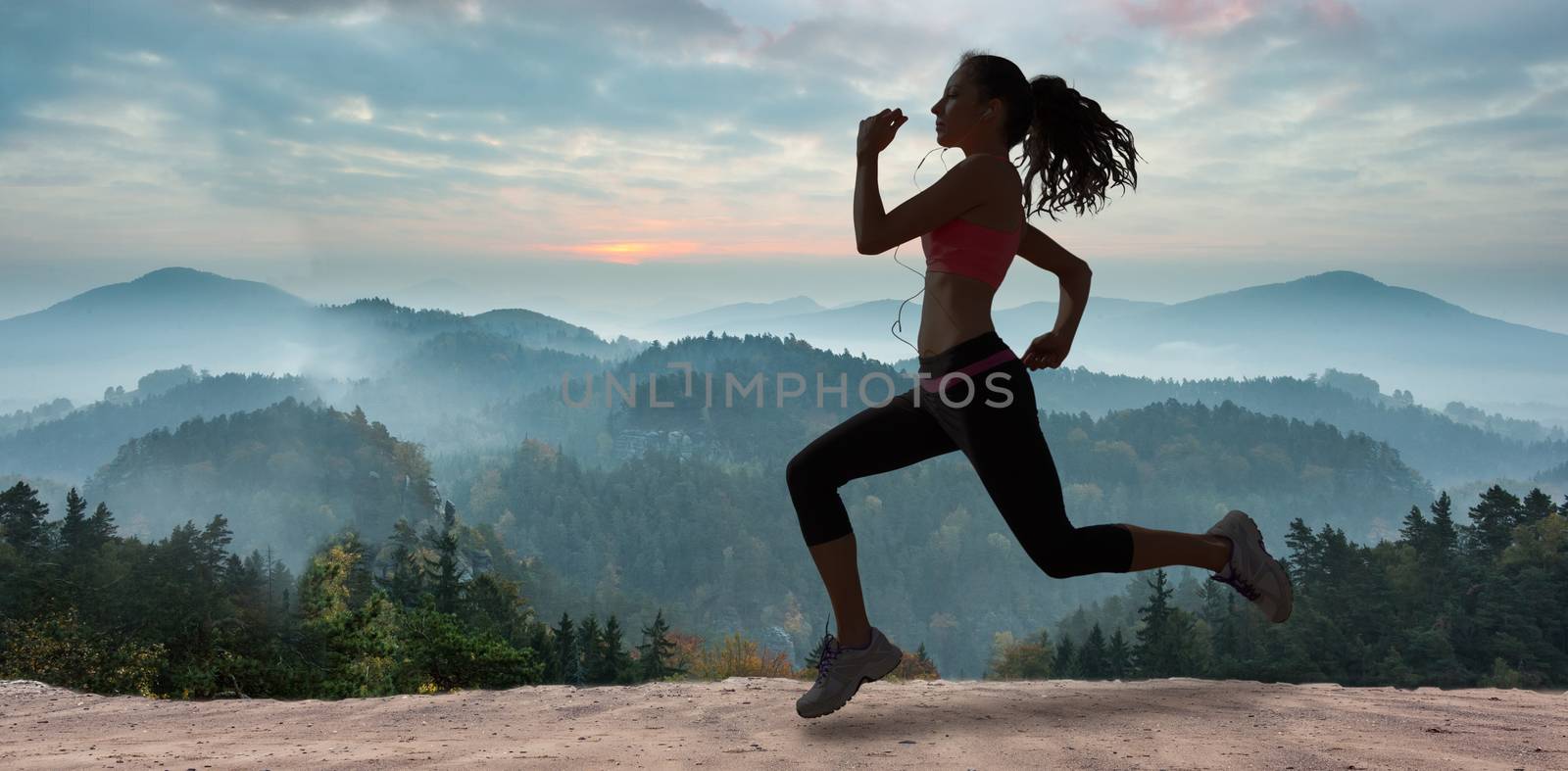 Full length of healthy woman jogging  against misty landscape
