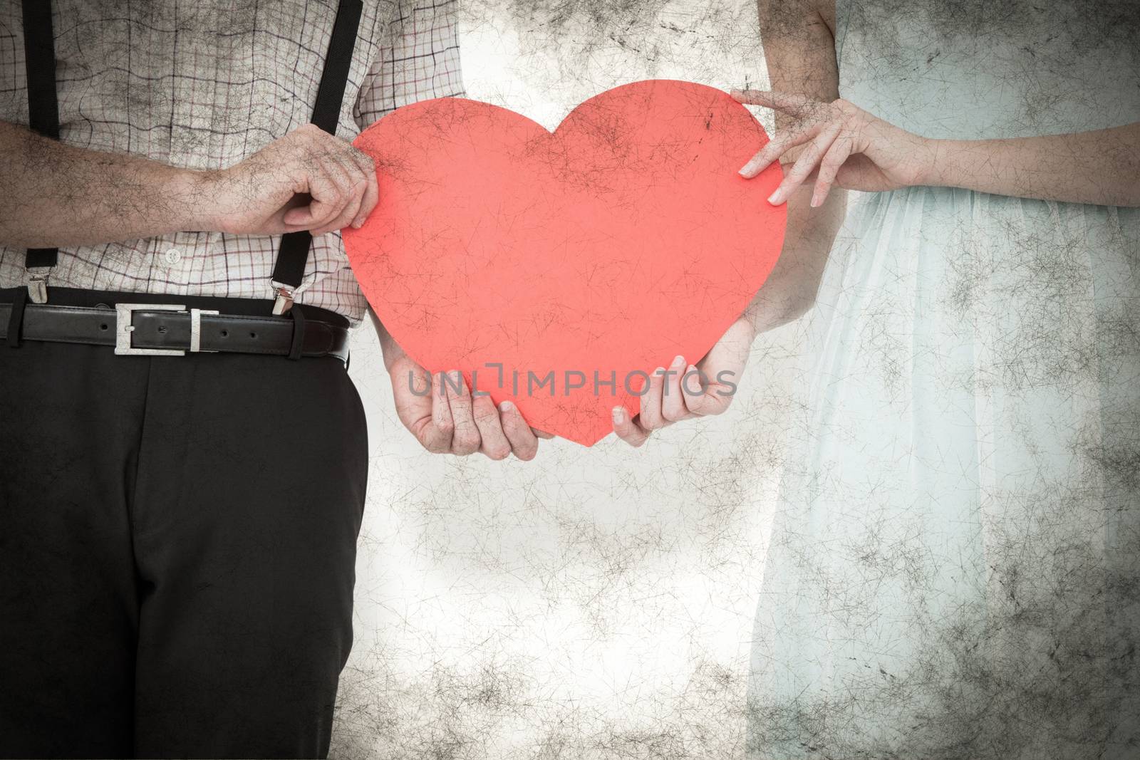 Hipster couple holding heart card against grey background