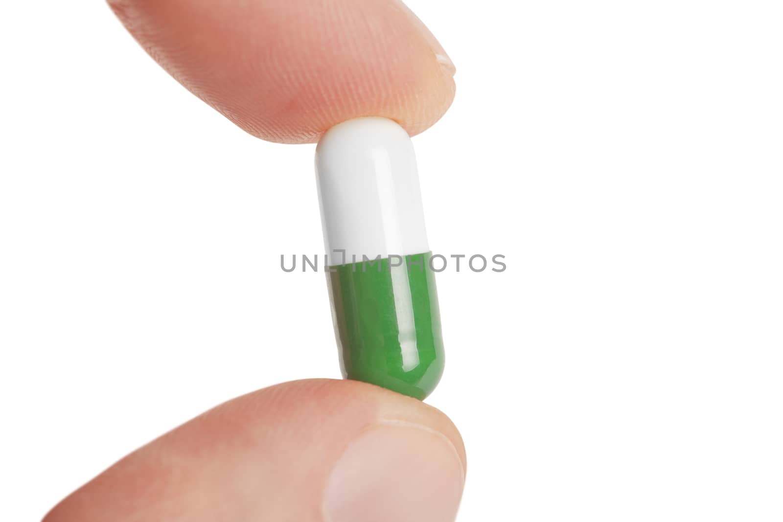 fingers hold the capsule pills isolated on white