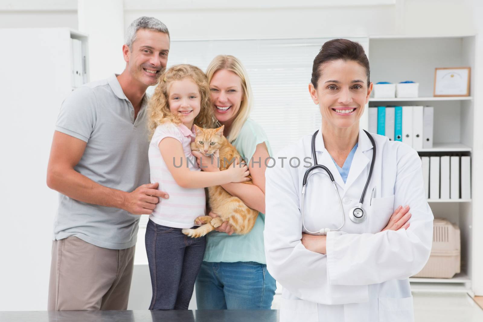 Veterinarian and cat owners smiling at camera  by Wavebreakmedia
