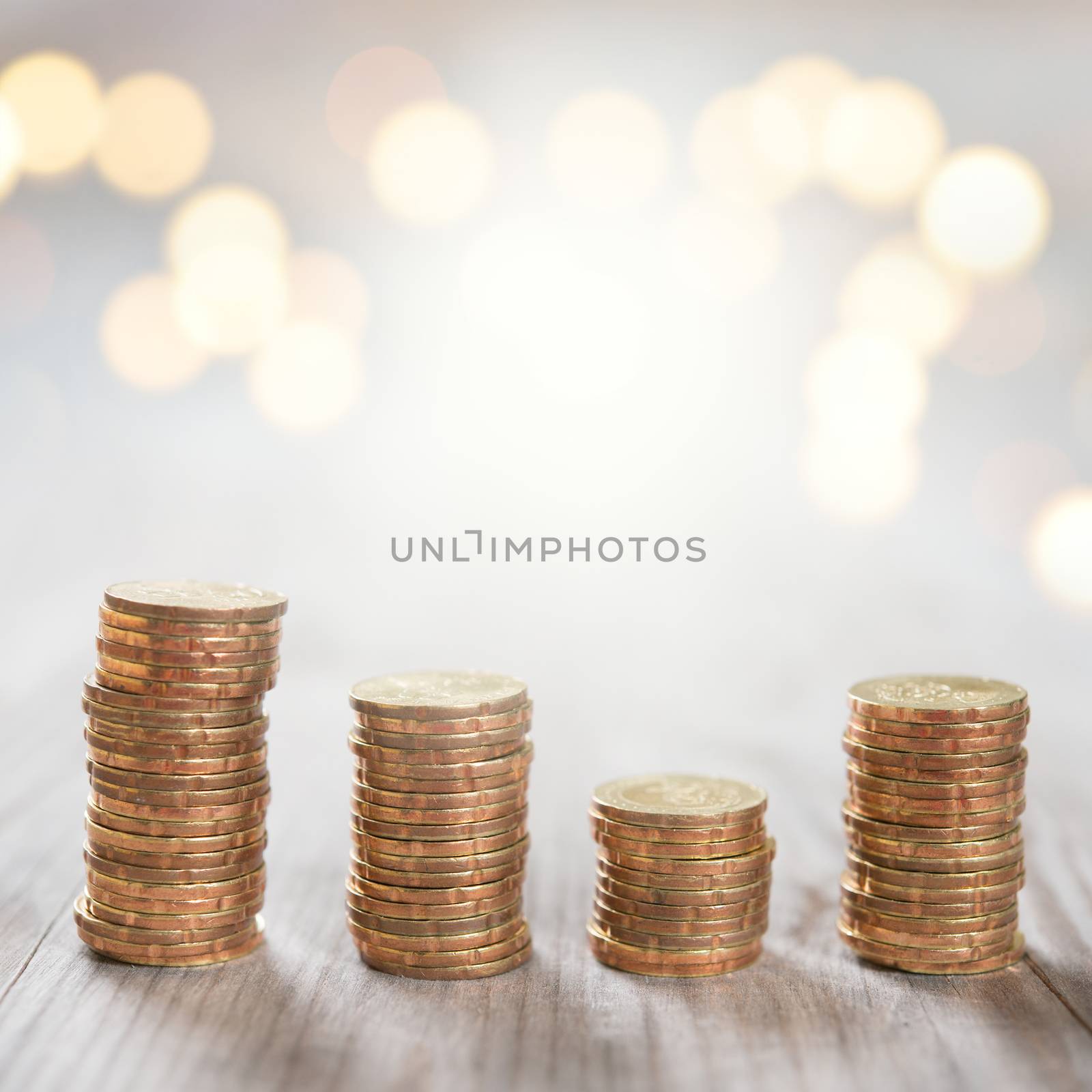 Coins stack in row on wooden background, financial concept. Focus on foreground with blur shinny background.
