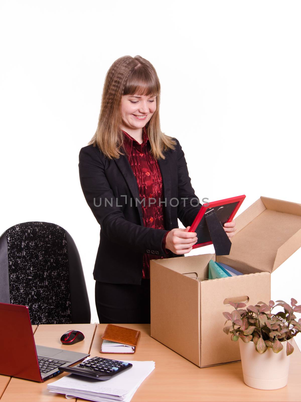 The girl accepted a job at the office and arranges personal belongings at the new workplace