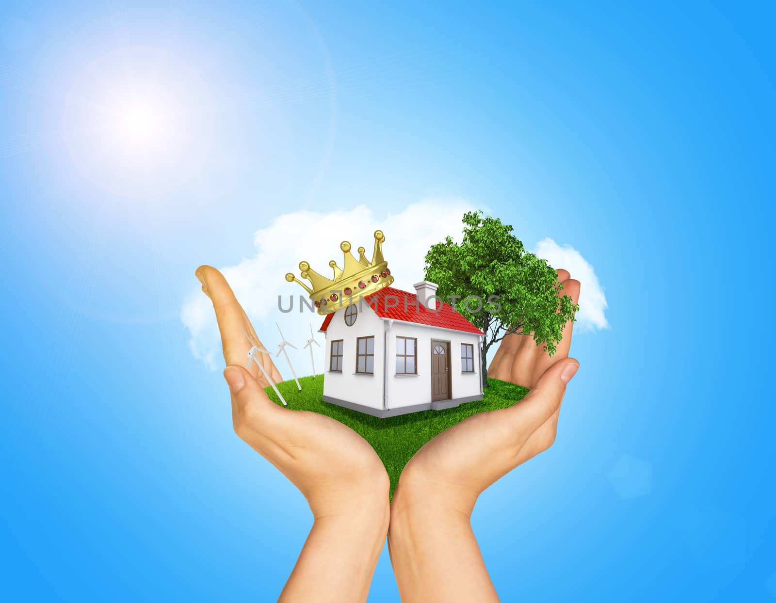 Hands holding house on green grass with crown, red roof, chimney, tree, wind turbine. Background clouds and blue sky