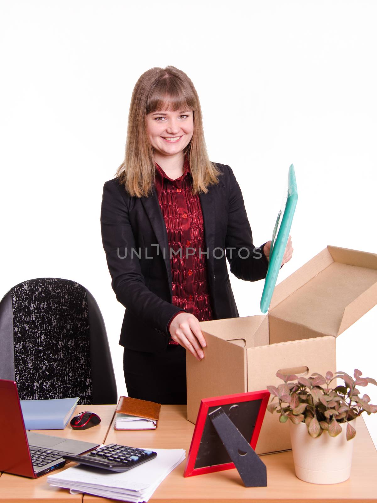 The girl accepted a job at the office and arranges personal belongings at the new workplace