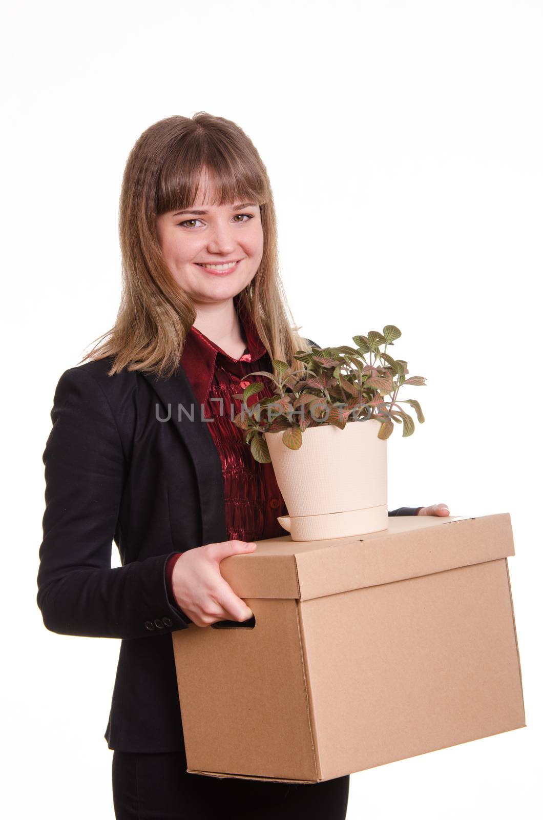 Smiling girl adopted at work in the office holding a box with things