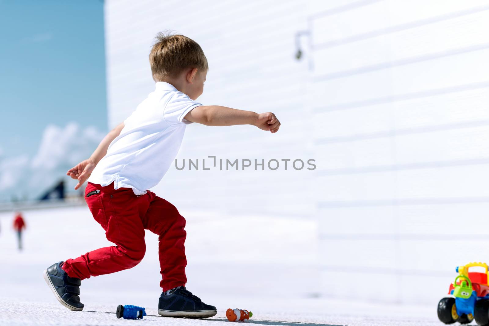 Little boy playing with toy car running by Nanisimova