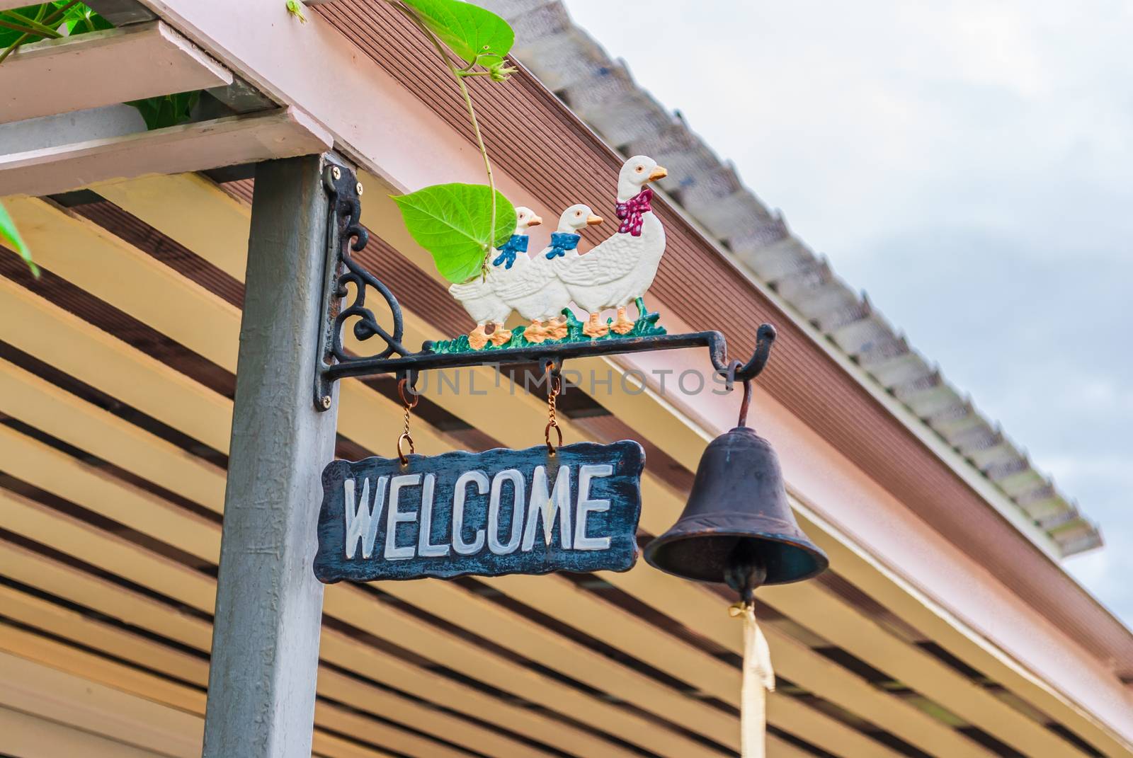 Welcome Sign with Bell and Duck Figures.