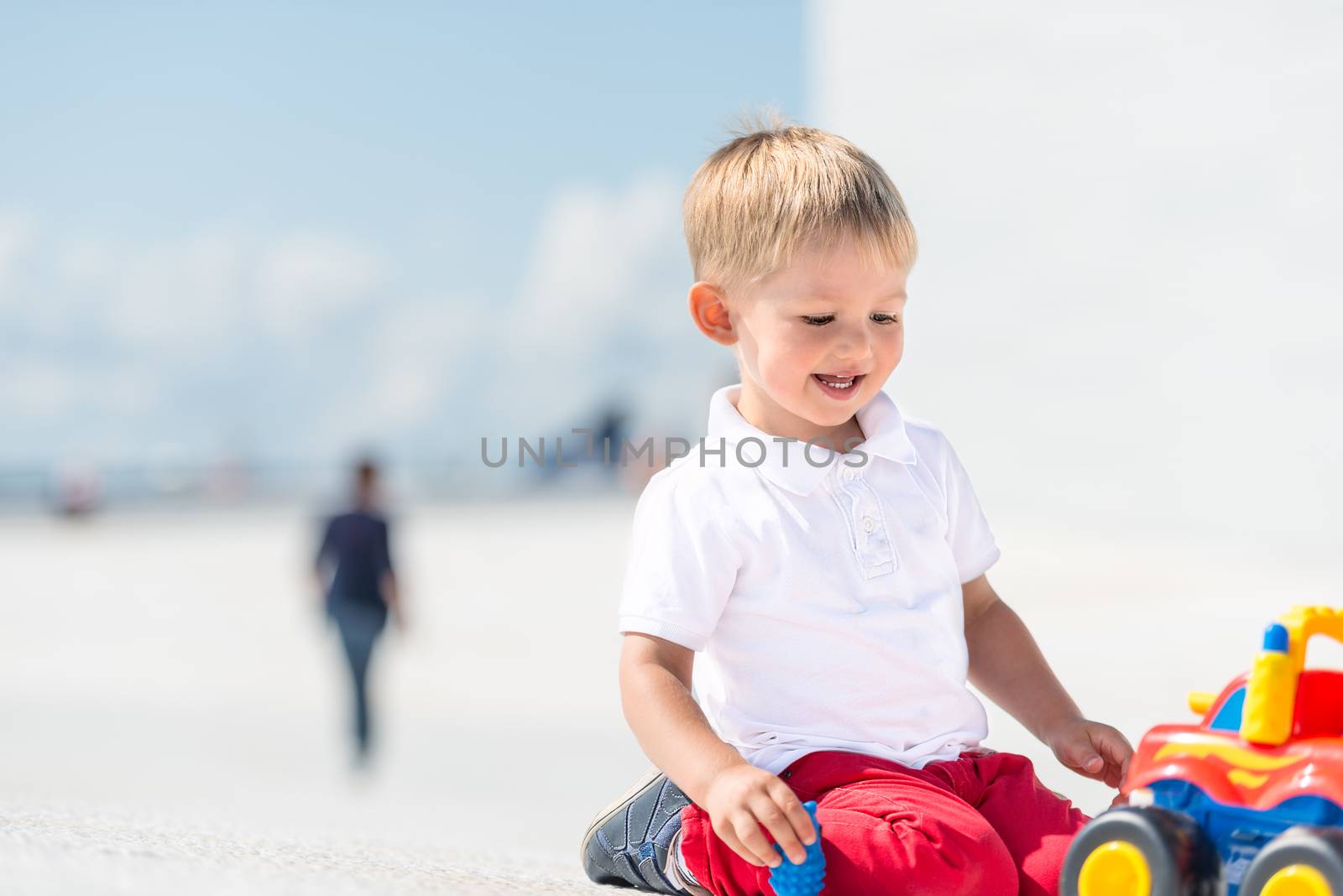 Little boy playing with toy car with copy space by Nanisimova